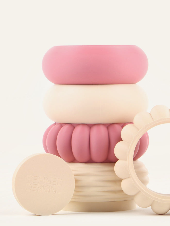 Close view of the Refined Design branded base plate leaning against a stacked vase