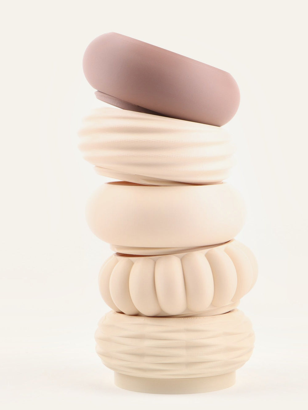 Modular vase stacked in cream tones with a mauve module resting on top